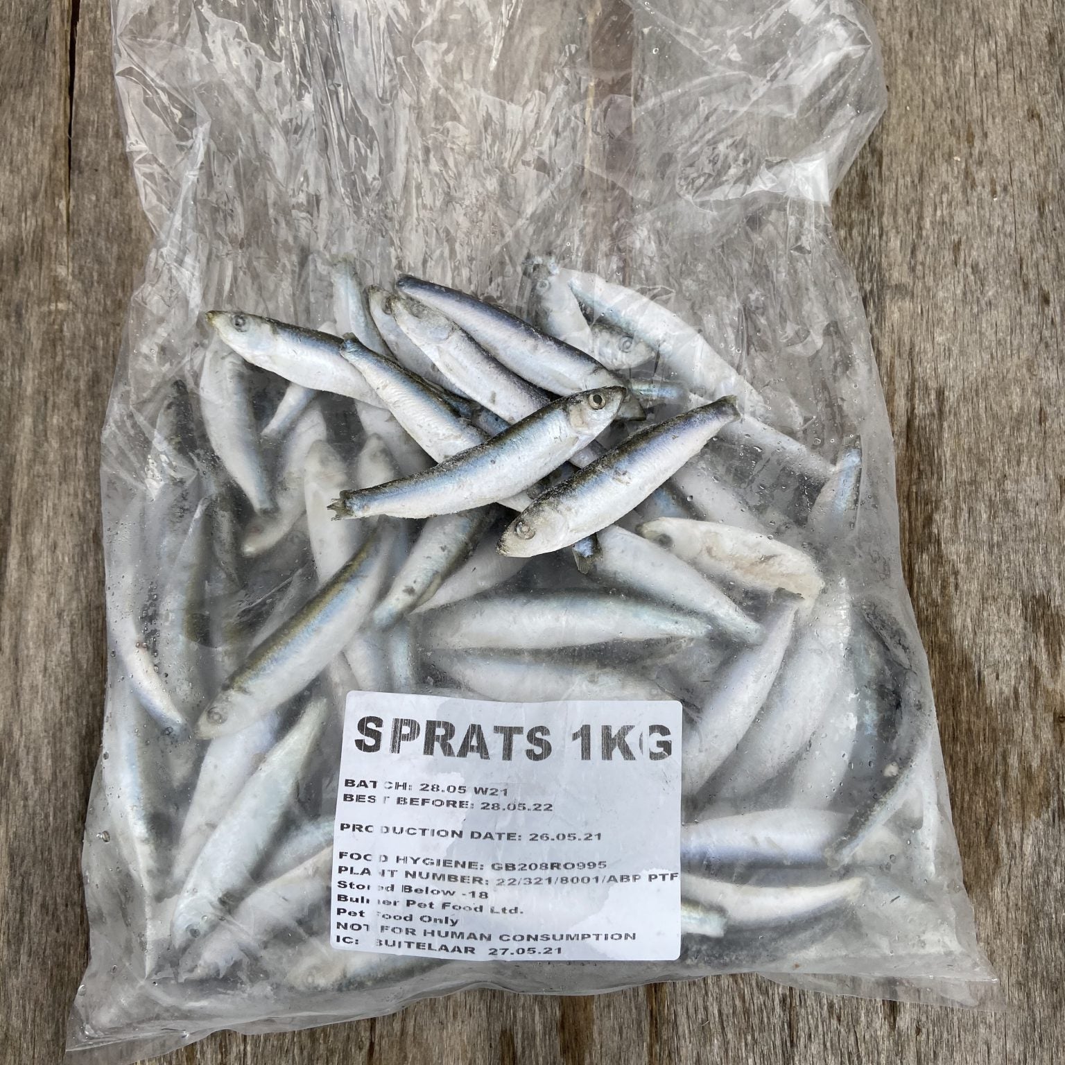 A 1KG bag of frozen sprats branded as Bulmer Sprats, packaged and displayed on a wooden surface.