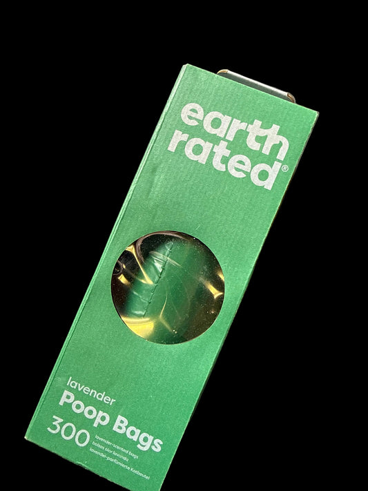 A green rectangular box of Earth Rated Lavender Poop Bags, showing a circular window with a green and gold foil bag inside, set against a solid black background.