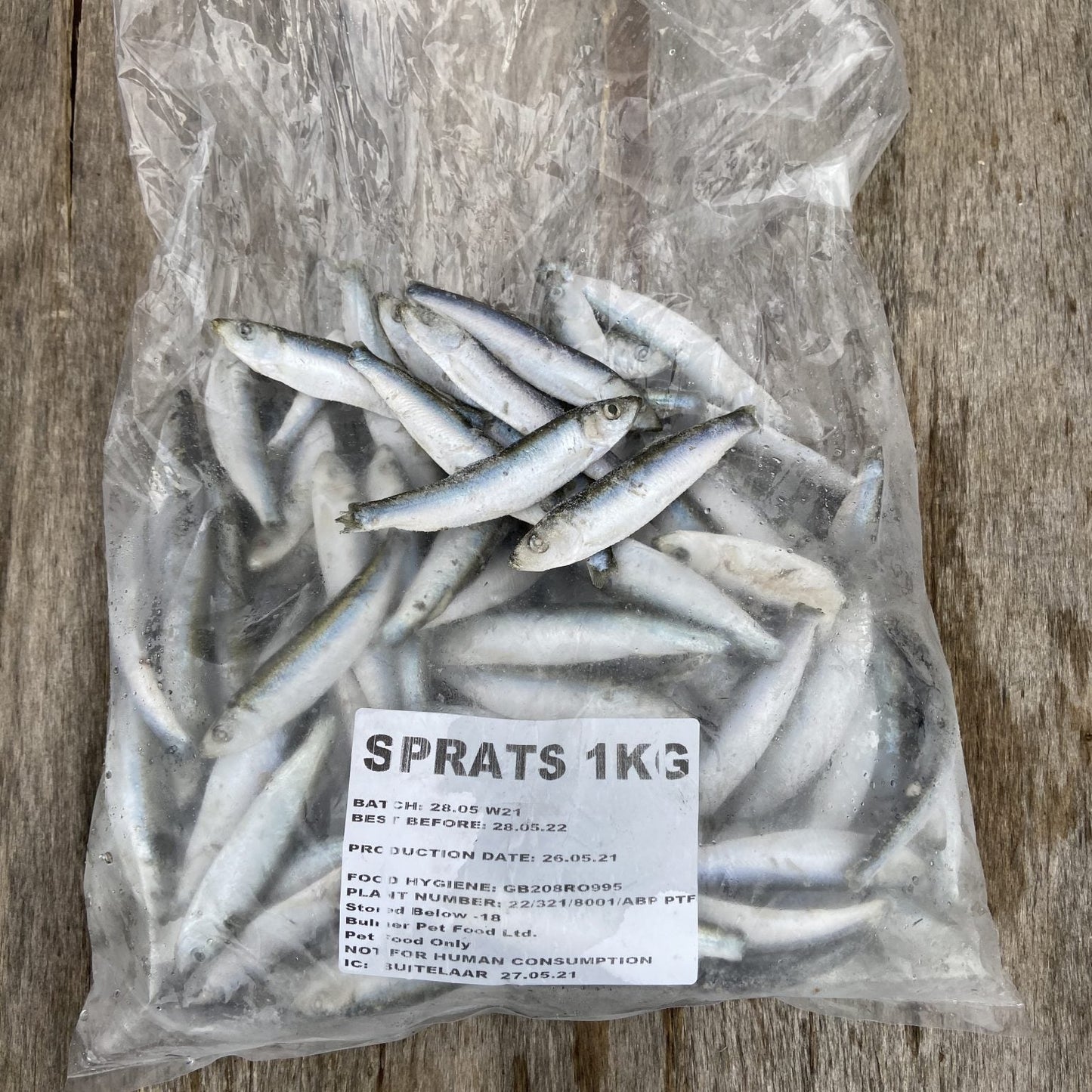 A 1KG bag of frozen sprats branded as Bulmer Sprats, packaged and displayed on a wooden surface.