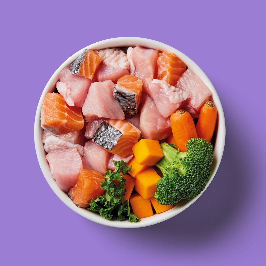 Assorted raw fish and vegetables in a bowl on a purple background